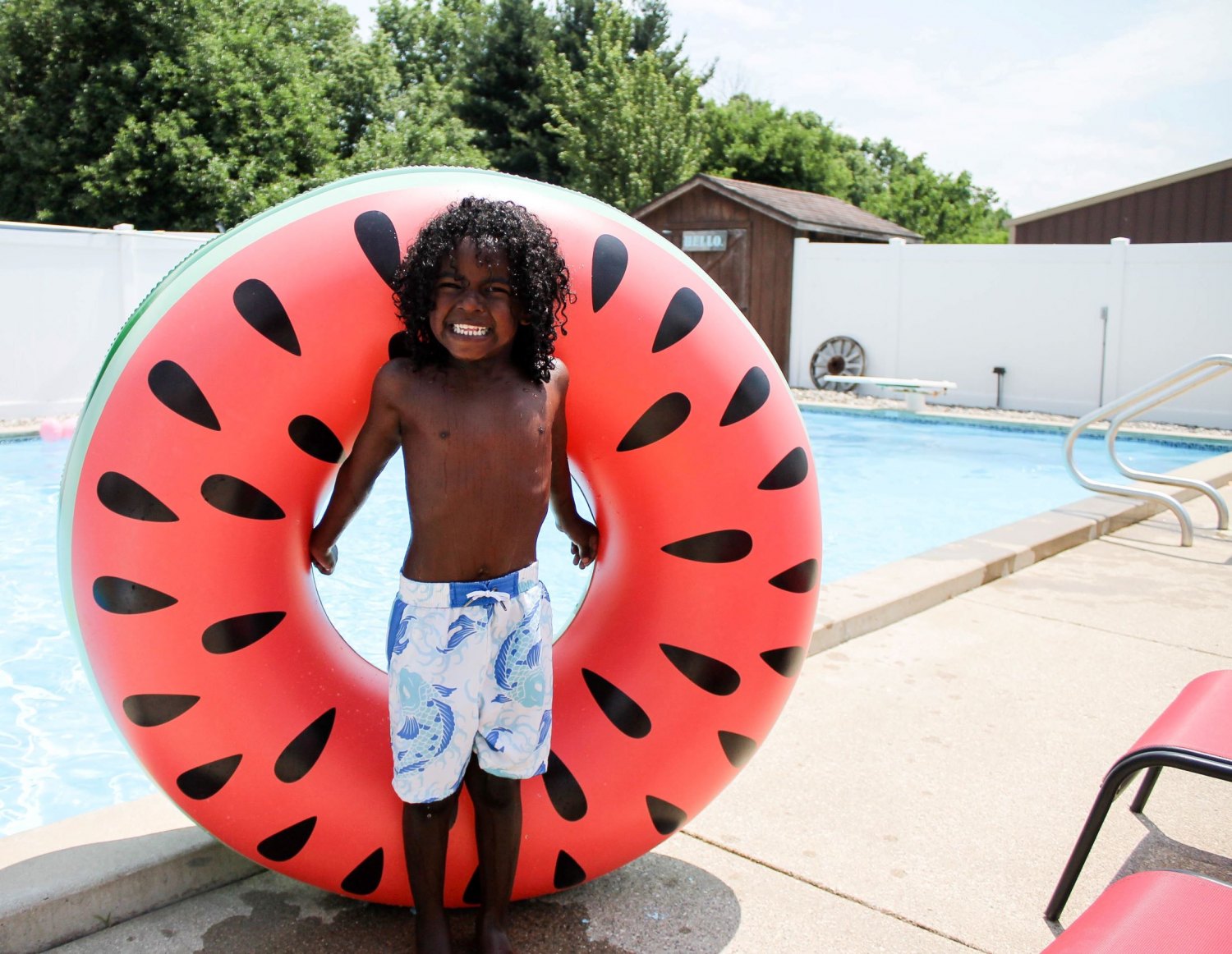 little boy at a pool with a huge watermellon innertube